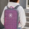 Mochila Converse All Star Morada Original | Mochila Unisex para Universidad y Uso Diario Mochila Converse All Star morada original puesta sobre la espalda de una mujer mostrando su tamaño real. Mochila unisex para universidad, trabajo, viajes y uso diario.