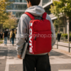 Estudiante universitario con mochila Levi’s roja 25L para portátil 15 pulgadas caminando por ciudad moderna