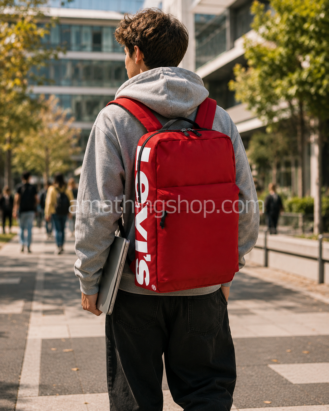 Estudiante universitario con mochila Levi’s roja 25L para portátil 15 pulgadas caminando por ciudad moderna