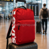 Mochila Levi’s roja 25L sobre maleta en aeropuerto moderno ideal para viaje y equipaje de mano