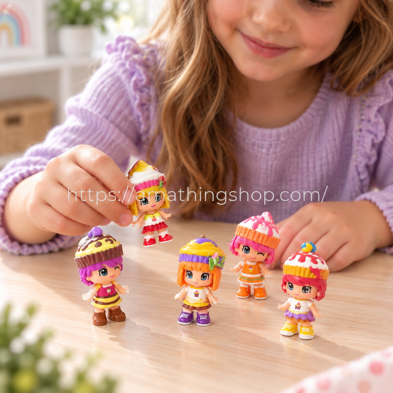 Niña sujetando una muñeca Pinypon Cupcakes junto a otras cuatro figuras con peinados de pastelitos sobre una mesa.