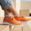 Primer plano de zapatillas Vans Iso 2.0 Rapidweld color naranja para mujer, suela blanca y tejido técnico en ambiente de terraza.
