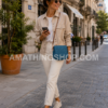 Mujer caminando por una ciudad europea con bolso Desigual Varsovia azul pequeño bandolera modelo 18WAXPXU cruzado