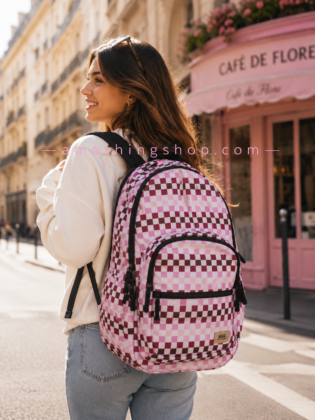 Mujer joven caminando por ciudad con mochila Vans rosa checkerboard grande estilo urbano. Imagen lifestyle optimizada para Google Imágenes, Pinterest y ecommerce de mochilas mujer.