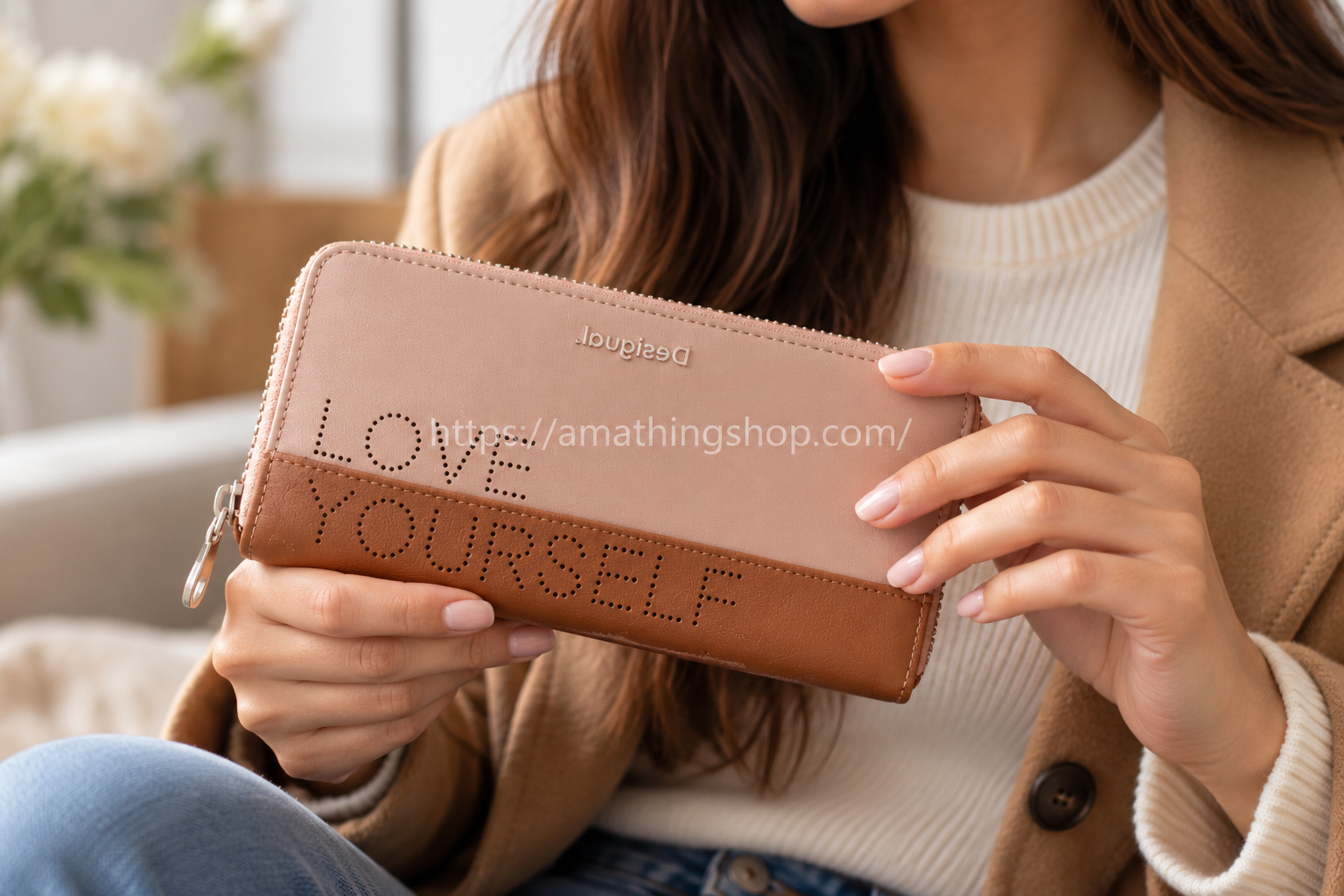 Mujer sosteniendo cartera Desigual Rhapsody LOVE YOURSELF rosa y marrón, modelo 20SAYP07, con cierre de cremallera.