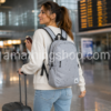 Mujer viajando en aeropuerto con mochila Jordan Gris Air Jordan original de 21 litros para portátil, equipaje de mano, universidad, trabajo y viajes.