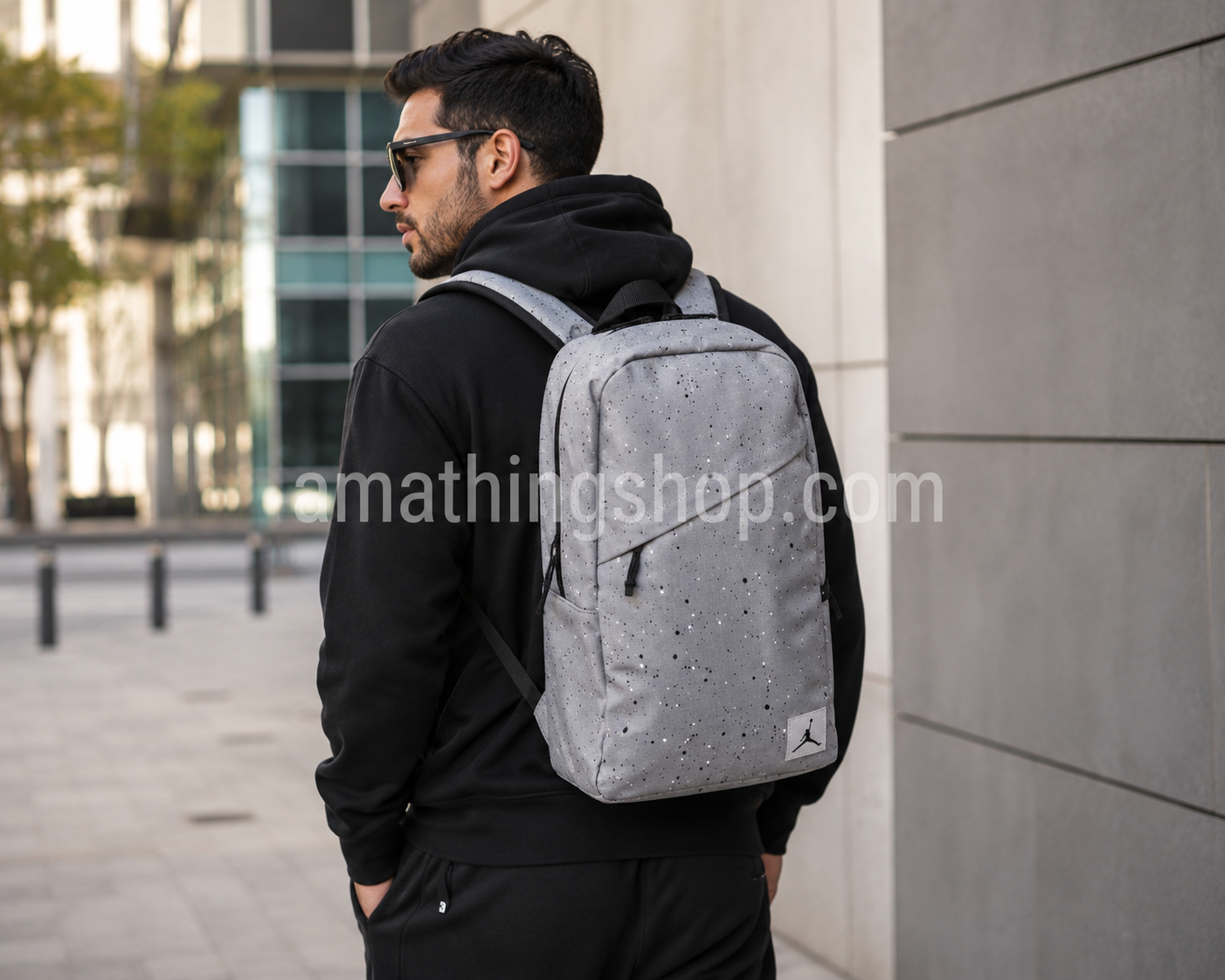 Hombre de 35 años con mochila Jordan Gris Air Jordan original de 21 litros durante un paseo urbano. Mochila unisex para portátil, universidad, trabajo, viajes y uso diario.