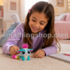Niña jugando con la mascota interactiva Lil' Gleemerz Amiglow original de Mattel con cola luminosa multicolor en una habitación infantil