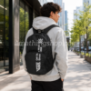 Mochila Vans Alumni Pack 3 B negra 27L puesta por un hombre joven en una calle urbana, ideal para universidad, trabajo, uso diario, estilo streetwear, skate y llevar portátil o accesorios.