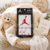 Canastilla de baby shower con el conjunto original Nike Air Jordan para bebé de 0 a 6 meses en su caja regalo con body, gorro y patucos blancos con logotipo Jumpman rojo
