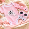 Canastilla para recién nacida con conjunto Jordan rosa formado por body, diadema y patucos sobre manta suave.