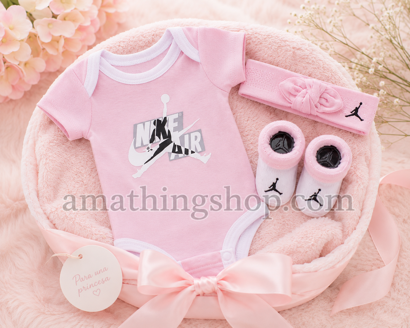 Canastilla premium para recién nacida con body Jordan rosa, diadema y patucos en tonos pastel.