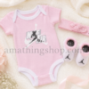 Conjunto Jordan Jumpman para bebé niña compuesto por body rosa, diadema y patucos sobre manta suave en tonos pastel.