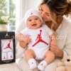 Madre abrazando a un bebé con conjunto Nike Air Jordan de tres piezas blanco y rojo compuesto por body, gorro y patucos modelo MJ0041-001