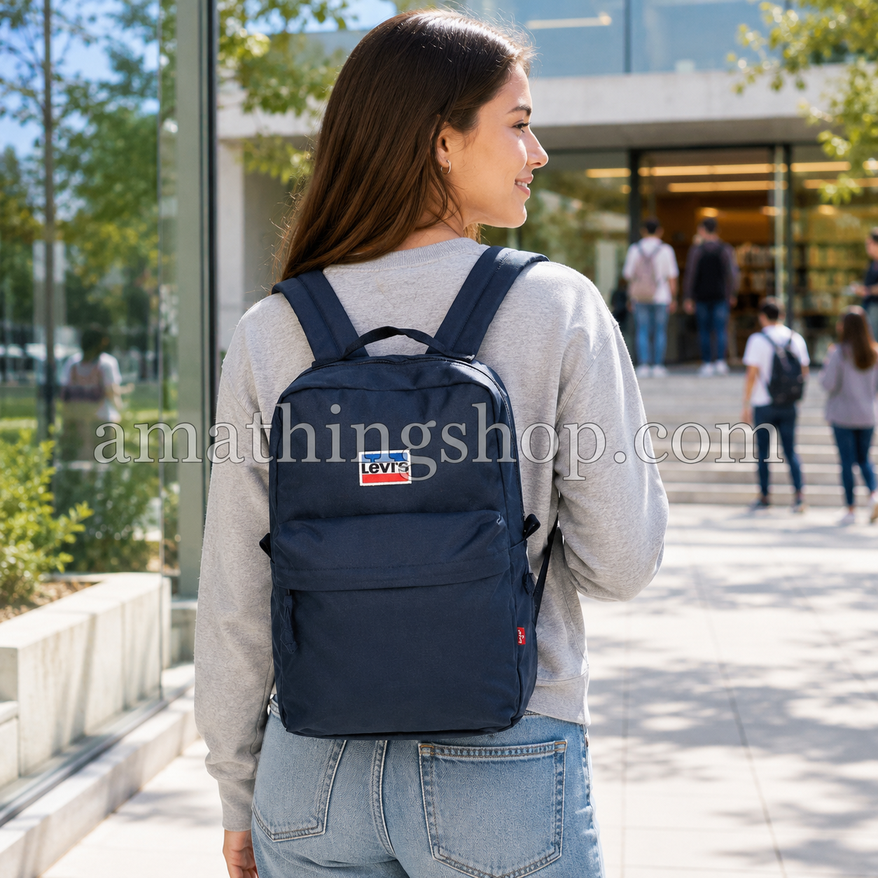 Mochila Levi’s Mini L Pack azul marino 13L puesta por una mujer joven en un campus universitario, ideal para clase, universidad, instituto, trabajo, paseos diarios y uso urbano.