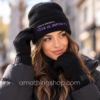Mujer con gorro negro Desigual Love Is Infinity y guantes negros a juego en un look de invierno