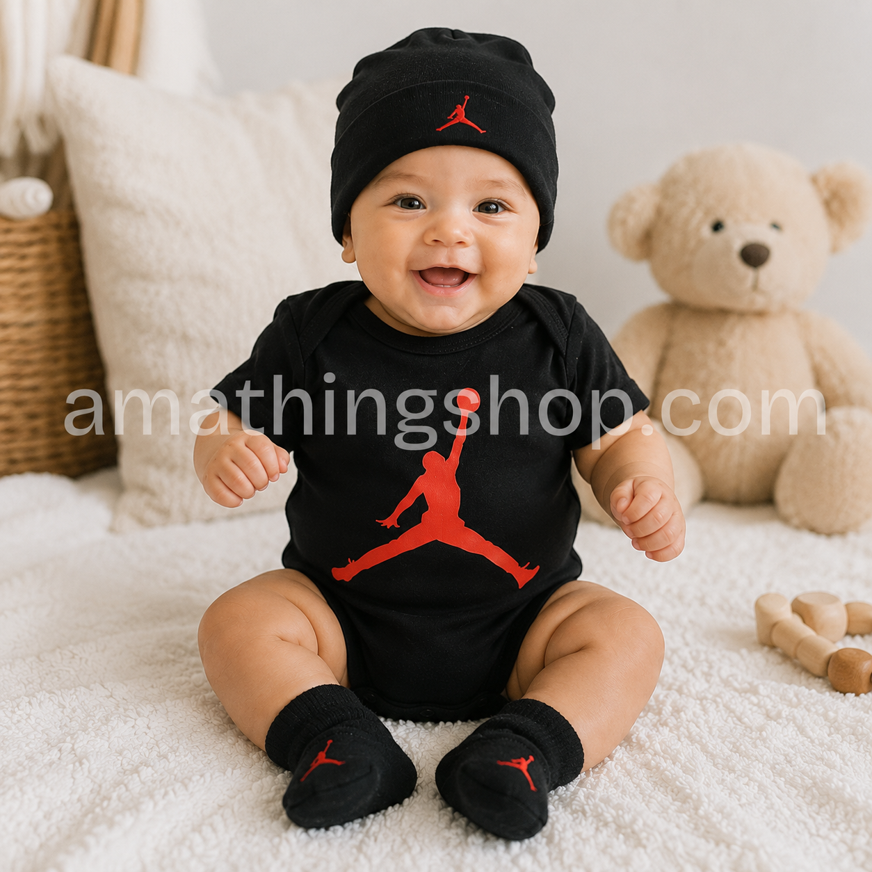 Bebé sentado con conjunto oficial Nike Jordan formado por body negro, gorro y patucos Jumpman rojos en una habitación infantil