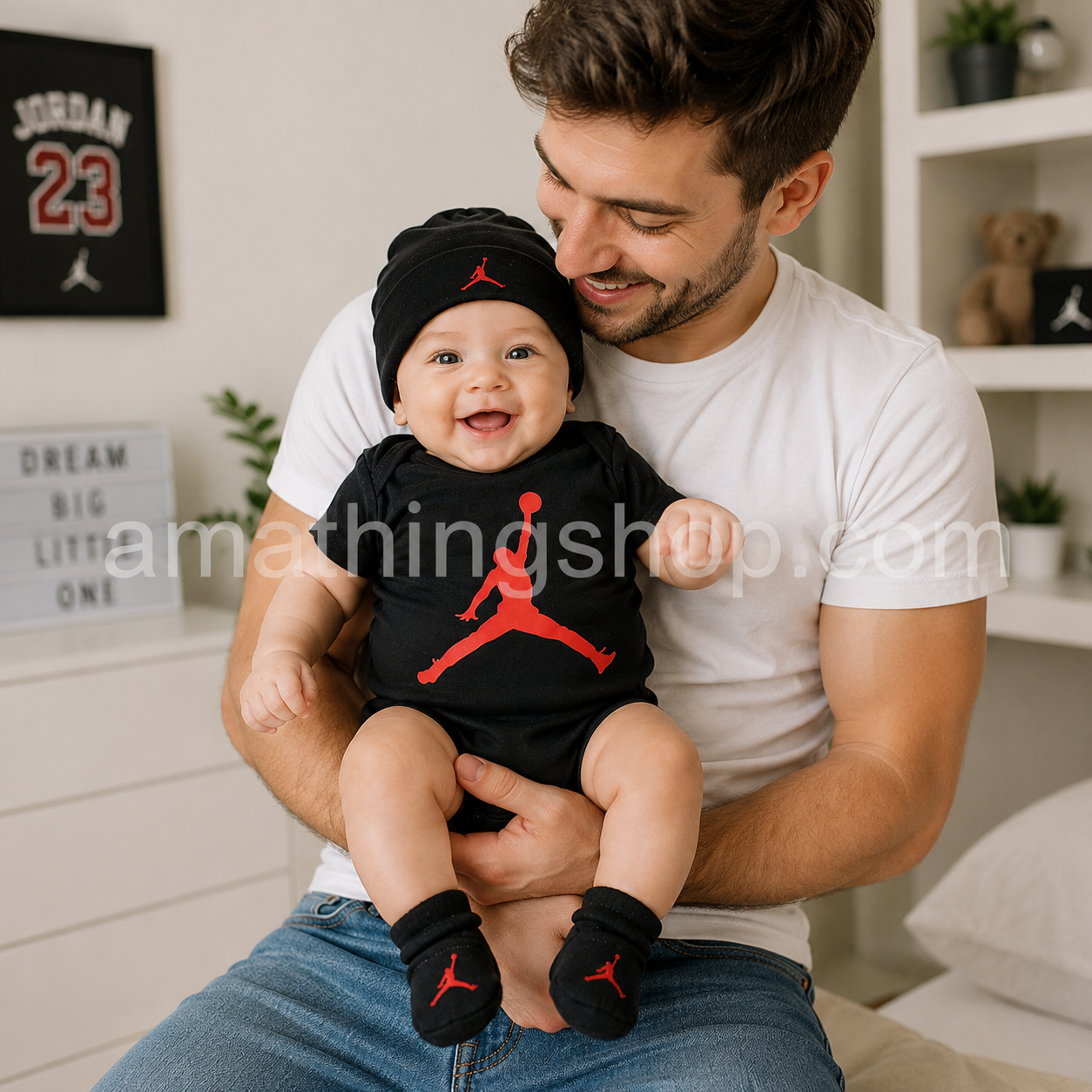 Padre sujetando a un bebé vestido con el conjunto oficial Nike Jordan de body negro, gorro y patucos con logotipo Jumpman rojo