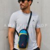 Hombre usando bandolera Nike Jordan portabotellas azul y amarillo tipo crossbody para gimnasio, viajes y uso diario urbano.
