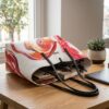 Bolso Desigual Sicilia reversible blanco para mujer colocado sobre mesa mostrando capacidad interior con objetos de uso diario en un ambiente luminoso y elegante.
