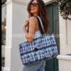 mujer usando bolso grande desigual azul tie dye para viaje gimnasio uso diario moderno y amplio