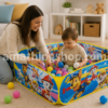 Madre jugando con un niño pequeño dentro de una piscina de bolas Paw Patrol con pelotas de colores en casa.