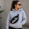 Mujer usando riñonera Jordan PSG negra unisex tipo crossbody en ambiente urbano lifestyle.