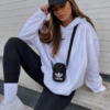 Mujer joven con bolso bandolera Adidas Originals Fest Bag EI7411 negro unisex pequeño cruzado para uso diario, viajes y estilo streetwear.
