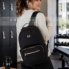 Mujer usando mochila Under Armour negra en gimnasio moderno lifestyle deportivo