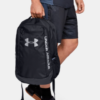 Persona llevando la mochila Under armour hustle negra en un entorno urbano