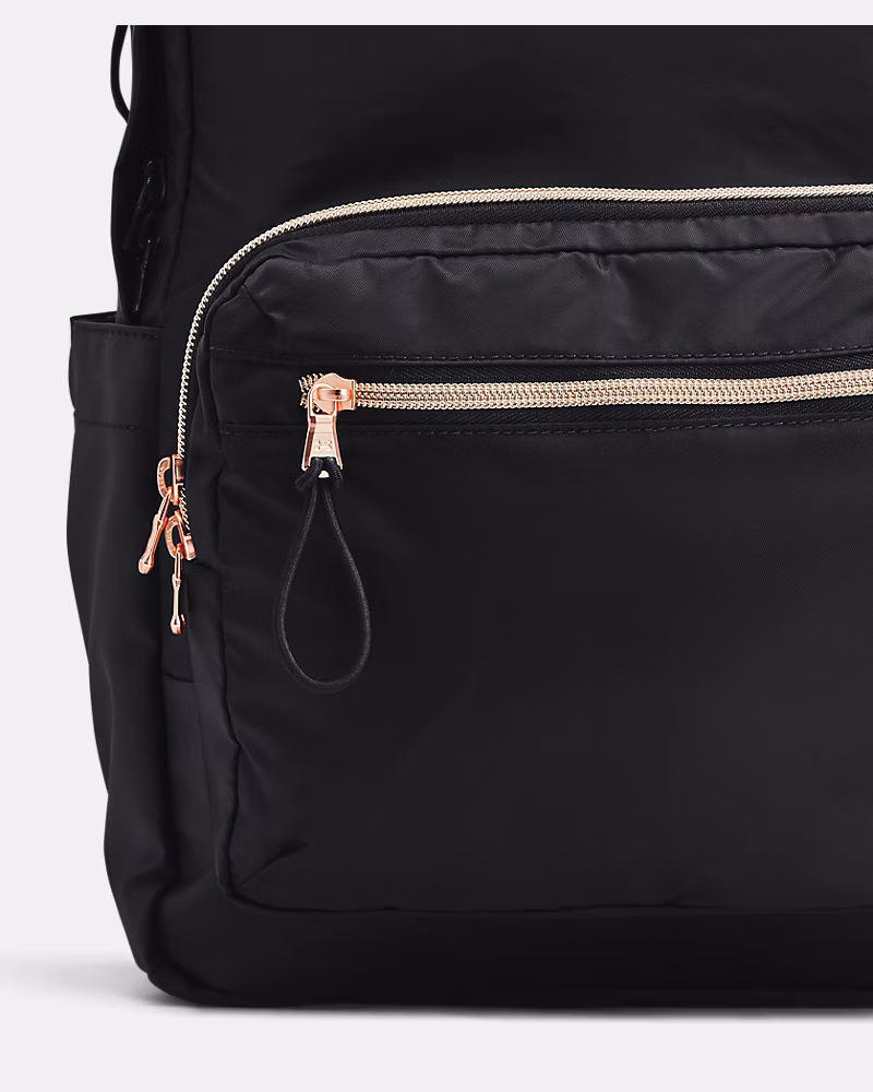 Detalle del bolsillo frontal de la mochila Under Armour Favorite negra con cremallera dorada