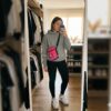 Mujer con bolso Jordan rosa bandolera en outfit casual frente a espejo, ideal para uso diario, looks urbanos y llevar móvil cómodamente.