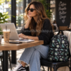 Mujer con mochila Vans Deana III Califas Black floral negra en cafetería trabajando