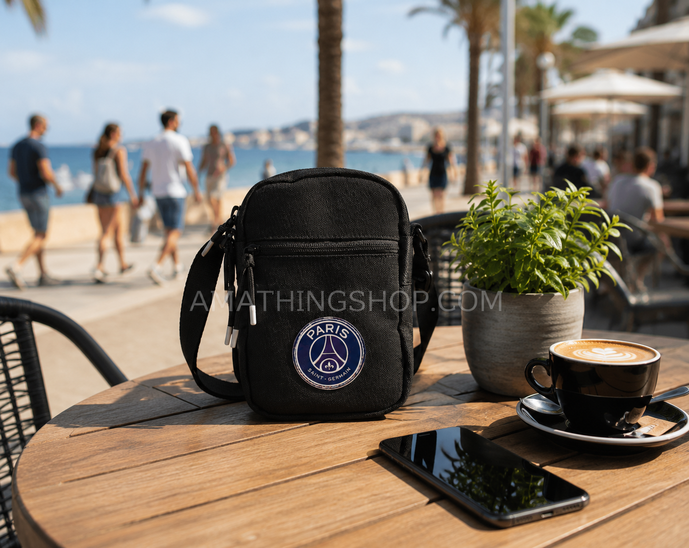 Bolso bandolera Jordan Paris Saint-Germain negro sobre mesa de cafetería frente al mar con café y móvil, accesorio urbano oficial PSG para hombre y mujer