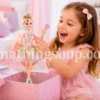 Niña feliz abriendo caja regalo rosa con muñeca Sparkle Girlz bailarina en habitación infantil pastel