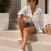 Mujer usando chanclas Adidas rosas con tres bandas blancas sentada en unas escaleras exteriores durante un día de verano.