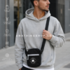 Hombre usando bandolera Converse negra estilo urbano casual Hombre joven usando bandolera Converse negra crossbody en ciudad estilo urbano casual.