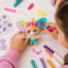 Niña decorando un muñeco The Beasties Bellies Arty con rotuladores y accesorios en una actividad de manualidades creativas.