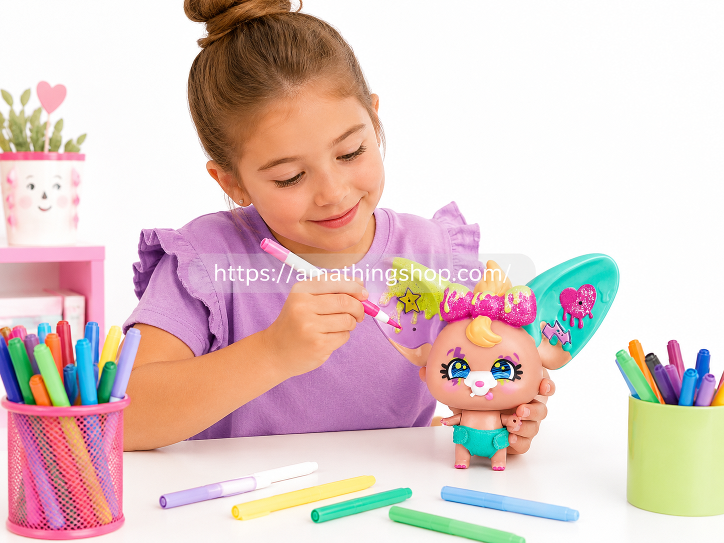 Niña decorando y personalizando un muñeco The Beasties Bellies Arty con rotuladores de colores en una mesa creativa.