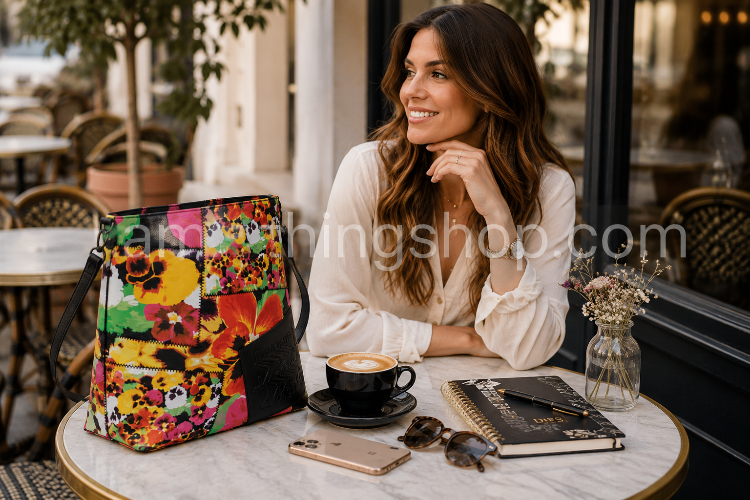 Bolso bandolera Desigual Mika Butan Floral multicolor sobre una mesa de cafetería con café, agenda, móvil y gafas. Imagen lifestyle para mujer con bolso shopper floral grande y elegante.