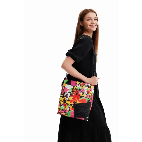 Mujer llevando bolso bandolera Desigual Mika Butan Floral multicolor grande con estampado floral patchwork.
