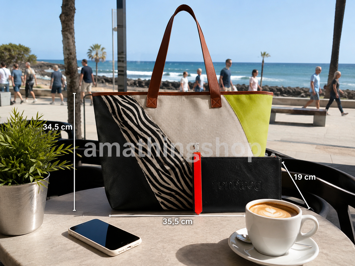 Bolso Desigual Shopper Namibia Grande original para mujer sobre mesa de cafetería con café, móvil, planta y vistas al mar