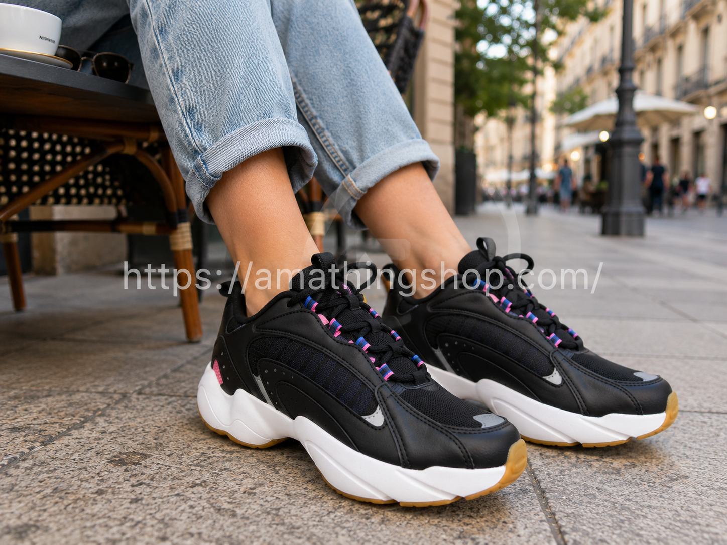 Zapatillas Reebok Royal Pervader para mujer negras con detalles rosa y azul modelo EH2488 en una mujer sentada en una cafetería urbana con look casual