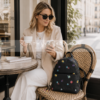 Mujer elegante en cafetería usando mochila Desigual floral negra estilo urbano lifestyle