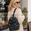 Mujer rubia usando mochila Desigual negra con flores estilo urbano casual lifestyle