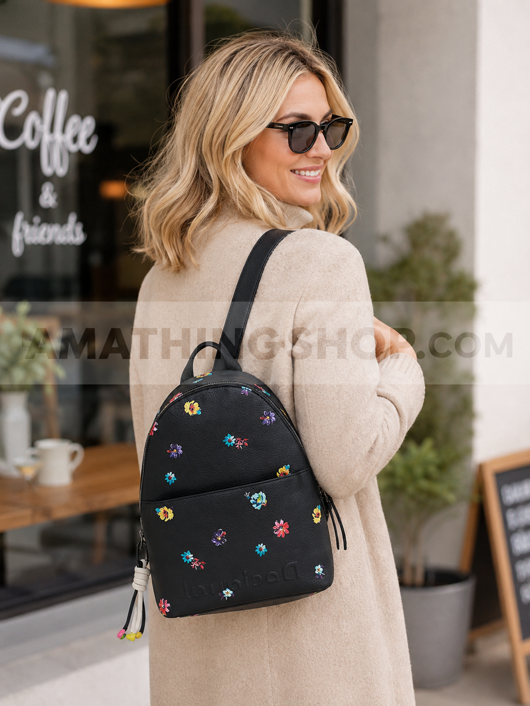 Mujer rubia usando mochila Desigual negra con flores estilo urbano casual lifestyle