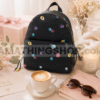 Mochila Desigual negra floral sobre mesa aesthetic estilo regalo para mujer