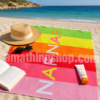 Toalla de playa Naf Naf rayas multicolor para mujer sobre arena junto al mar con sombrero, gafas y accesorios de verano. Toalla grande de algodón ideal para playa, piscina y vacaciones.