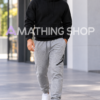 Hombre de 35 años con pantalón Jordan Jumpman gris XL, logotipo negro, sudadera negra y zapatillas blancas en un entorno urbano. Copiar ALT