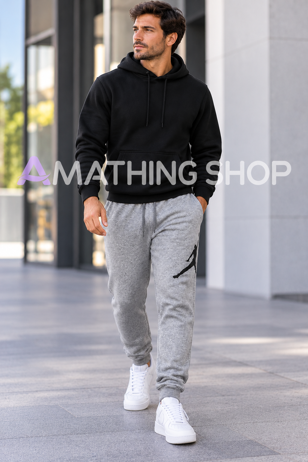 Hombre de 35 años con pantalón Jordan Jumpman gris XL, logotipo negro, sudadera negra y zapatillas blancas en un entorno urbano. Copiar ALT